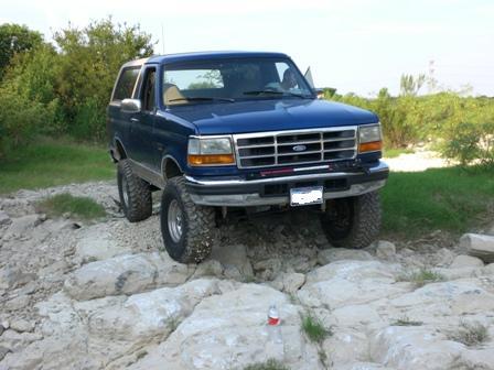 1996 Ford Bronco - A blue 1996 Ford Bronco navigates a challenging rocky path.