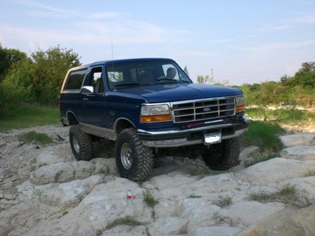 1996 Ford Bronco - Blue 1996 Ford Bronco navigating a rocky terrain.