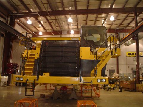 1966 International School Bus - This industrial vehicle is supported by jack stands in a large workshop environment.