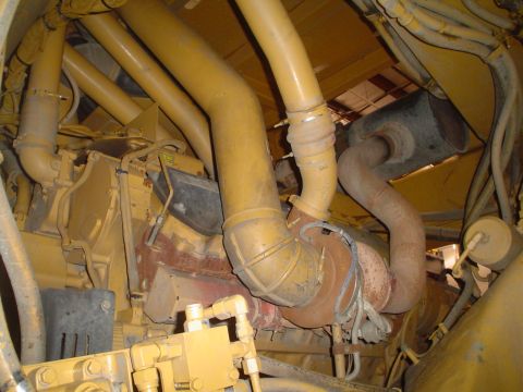 1966 International School Bus - The complex network of yellow pipes and engine parts within a vehicle's engine compartment is shown.