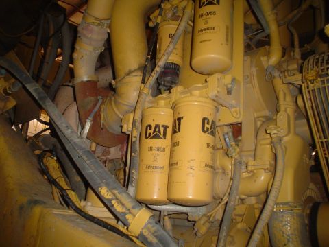 1966 International School Bus - Close-up view of yellow Caterpillar engine filters and hoses.