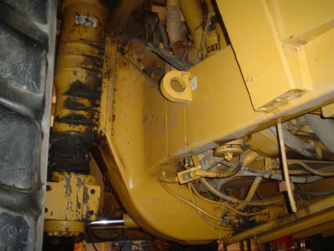 1966 International School Bus - Close-up view of the engine and tire of a yellow heavy machinery vehicle, with a visible CAT logo.