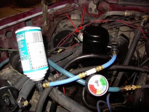 1988 Ford C-350 (Centurion Conversions) - A can of refrigerant is attached to a vehicle's AC system, with a pressure gauge monitoring the system.