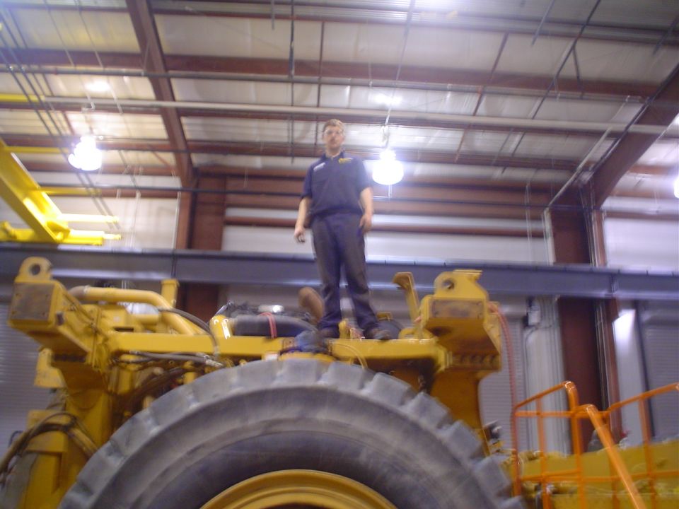 Yellow heavy machinery with a person standing on top