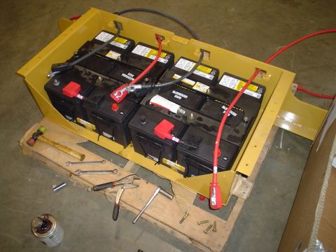 1966 International School Bus - A battery bank assembly with tools scattered around it, suggesting recent work or preparation.