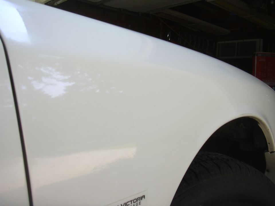 White 1997 Ford Crown Victoria fender with a small badge visible