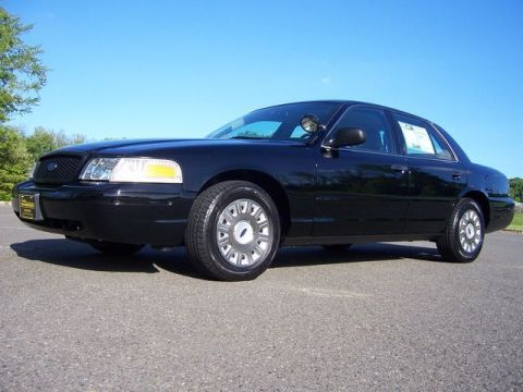 2003 Ford Crown Victoria - This black 2003 Ford Crown Victoria is shown from a three-quarter front view under a clear blue sky.
