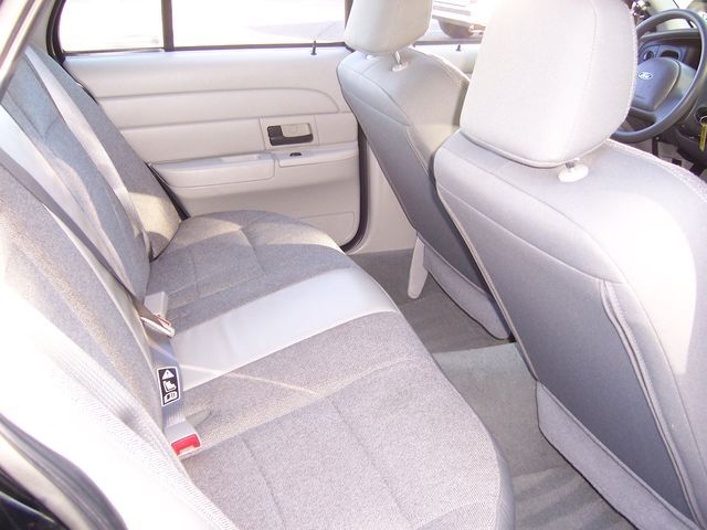 Interior of a 2003 Ford Crown Victoria showing gray cloth seats and door panel