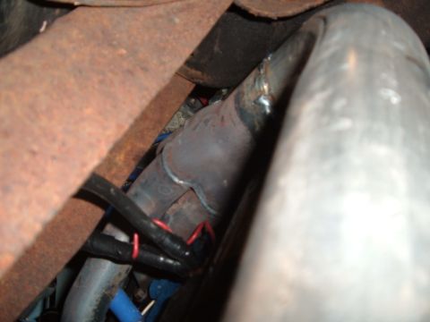 1990 Ford Ranger - Close-up view of vehicle exhaust piping and electrical wiring, showing signs of rust and wear.