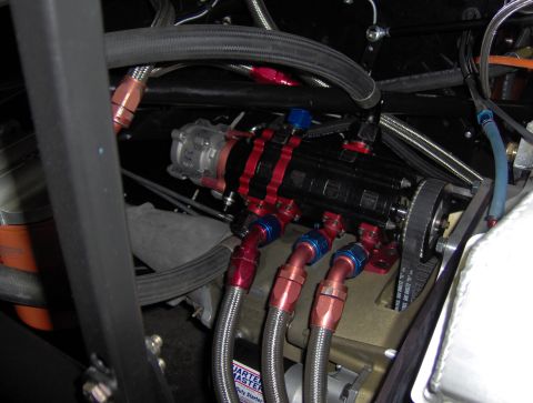 1978 Ford Bronco - Engine compartment detail showing a fuel pump, hoses, and a drive belt system.