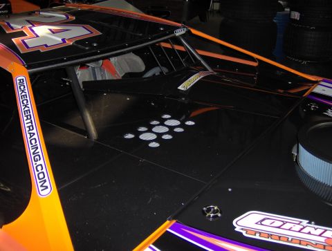 1978 Ford Bronco - A close-up view of a black racing car, orange and purple accents and the number 24 prominently displayed.