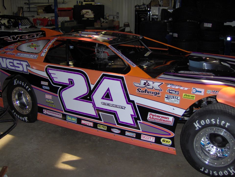 Orange and black race car with number 24 and various sponsor decals