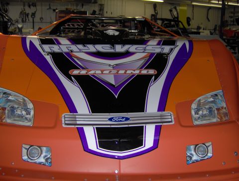 1978 Ford Bronco - Front view of an orange race car with racing decals and a Ford emblem on the grille.