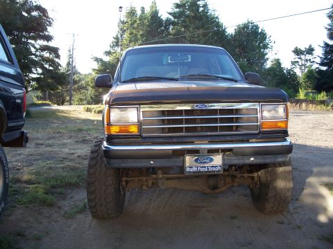 1990 Ford Bronco - Lifted 1990 Ford Explorer front view, parked outdoors next to another vehicle.