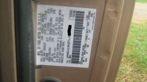 1996 Ford Bronco - Close-up of a Ford Motor Co. certification/VIN label affixed to a tan door jamb, showing manufacture date 10/95, GVWR and tire specs, VIN e…