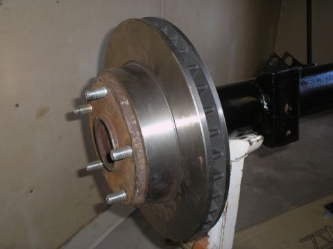 1990 Ford Bronco - Close-up of a vehicle's axle assembly, showing the brake rotor and wheel studs.
