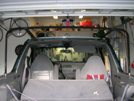 1995 Ford Bronco - The interior of a 1995 Ford Bronco is visible, seats, dashboard, and an aftermarket roll cage.