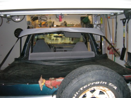 1995 Ford Bronco - Interior view of a green SUV with its soft top frame installed and a spare tire in the foreground.