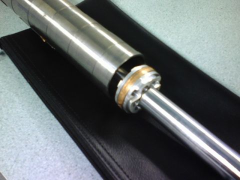 1984 Ford Bronco - Close-up view of a shock absorber component, a metallic cylinder and a brass-colored ring.