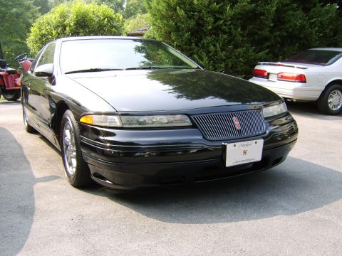1996 Mercury Grand Marquis - Black 1995 Lincoln Continental with custom grille and Maryland plate, parked outdoors with another vehicle.