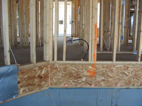 1995 Ford Bronco - The interior of a building shows exposed wood framing and electrical conduit during construction.