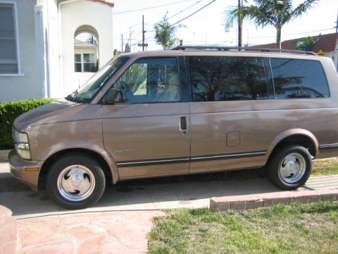 1968 Ford Mustang - Side view of a tan minivan, identified by the "ASTRO" badge on the door.