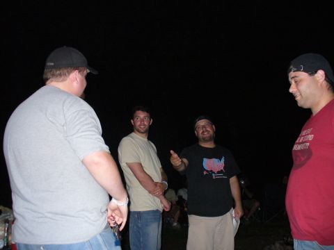 1991 Ford Probe - A group of men converse outdoors in the dark, with one man wearing a shirt depicting a map of the United States.