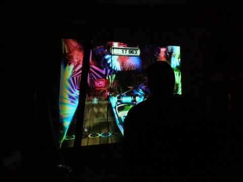 1991 Ford Probe - A person plays a video game, silhouetted against the vibrant, abstract visuals on the screen.