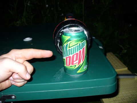 1991 Ford Probe - A hand points towards a can of Mountain Dew placed on a green table outdoors.