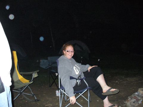 1991 Ford Probe - A woman relaxes in a camping chair at night, with tents visible in the dark background.