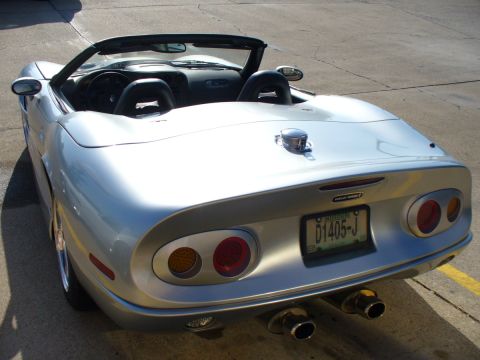 1995 Ford Thunderbird - This silver convertible sports car features a distinctive rear design with dual exhaust pipes and a custom license plate.