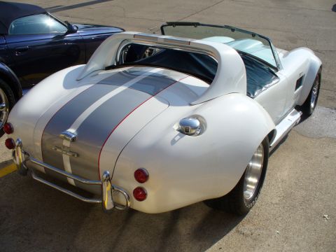 1995 Ford Thunderbird - White sports car with racing stripes and a blue convertible in the background.