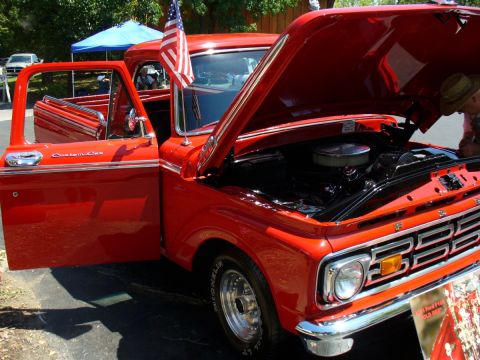 1995 Ford Thunderbird - This red 1965 Ford F-100 Custom Cab pickup has its hood open, revealing the engine bay.