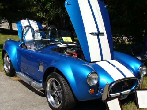 1995 Ford Thunderbird - Blue AC Cobra replica at a car show, hoods open.