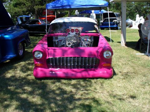 1995 Ford Thunderbird - A customized 1955 Chevrolet is displayed at an outdoor car show with its hood open, revealing a powerful engine.