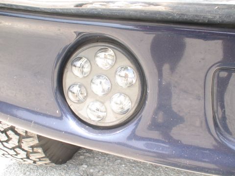 1993 Ford C-350 (Centurion Conversions) - A circular LED light assembly is mounted on the front bumper of a vehicle.