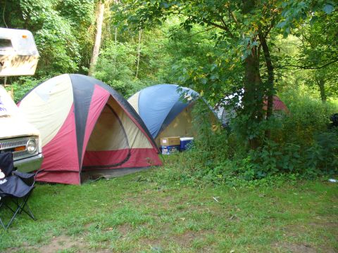 1991 Ford Probe - A campsite scene with tents, a trailer, and a vehicle parked nearby.