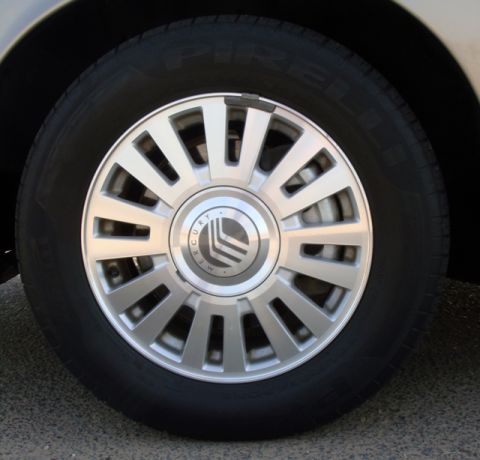 2007 Mercury Grand Marquis - A close-up view of a Mercury wheel, the brand's emblem in the center.