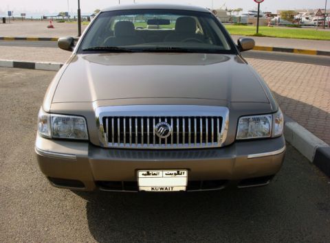 2007 Mercury Grand Marquis - Head-on front view of a bronze Mercury Grand Marquis sedan with its chrome waterfall grille, Mercury emblem and clear multi-reflector headl…