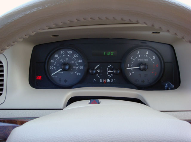 Dashboard gauge cluster with speedometer, tachometer, and PRND21 shifter indicator in tan dash