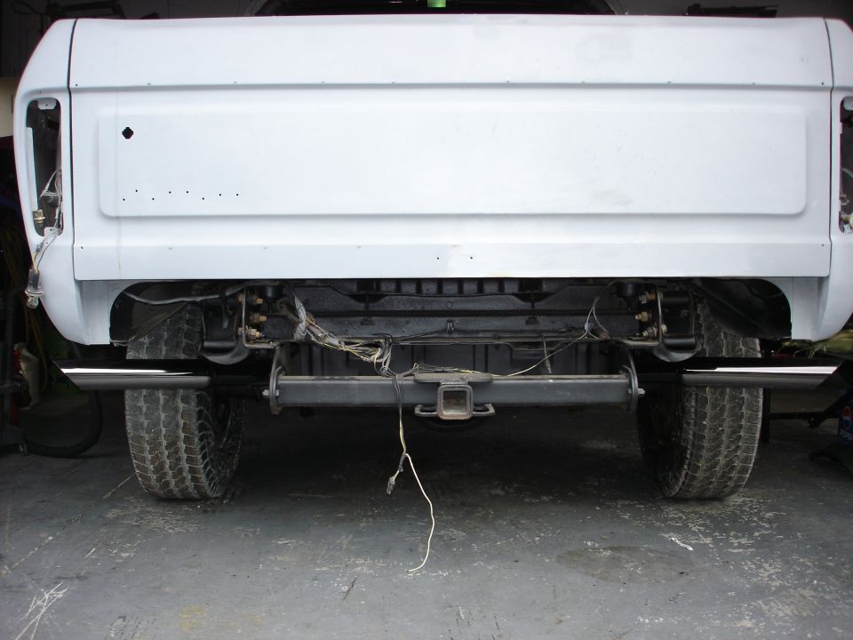 Rear view of white pickup truck with dual exhaust and trailer hitch
