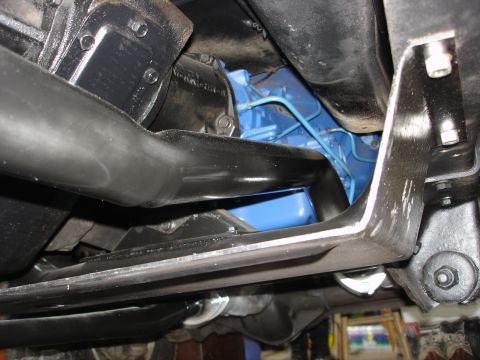 1979 Ford Bronco - Close-up of a vehicle's undercarriage, focusing on the engine and exhaust system components.