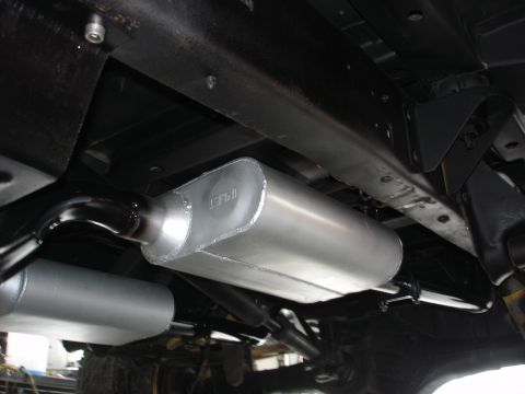 1979 Ford Bronco - The underside of a vehicle shows a dual exhaust system with two prominent mufflers.