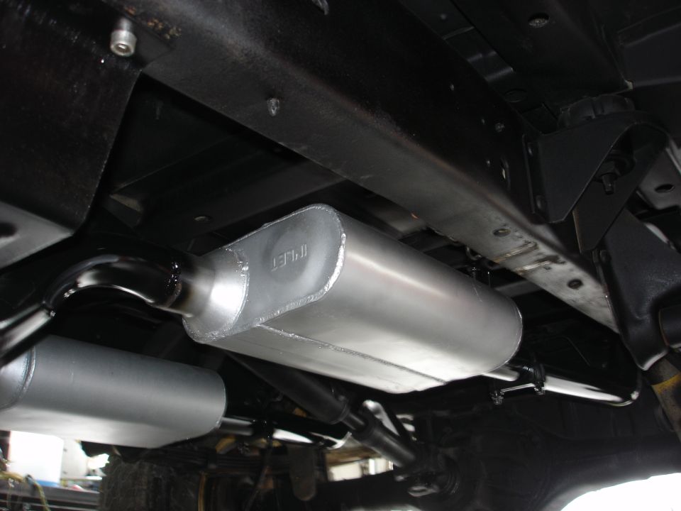 Underside view of a vehicle's exhaust system with two mufflers visible