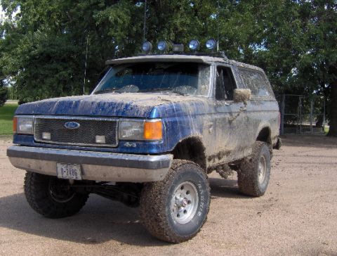 1987 Ford Bronco - This 1987 Ford Bronco is heavily coated in mud, suggesting recent off-road use.