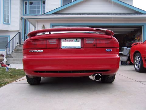 1994 Ford Probe - Rear view of a red car, identified as a Probe, with a spoiler and dual exhaust pipes.