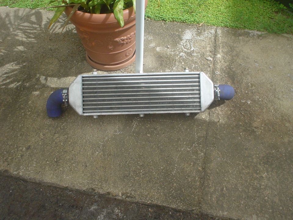 Front-mount intercooler with blue silicone couplers on a concrete patio