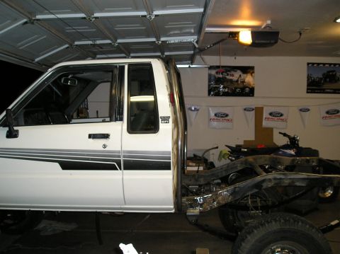 1986 Toyota Hilux - The side view of a white 1986 Toyota Hilux pickup truck cab, showing a custom tube bed frame in progress.