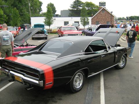 1988 Mercury Grand Marquis - A black 1969 Dodge Charger with red racing stripes is parked at a car show.