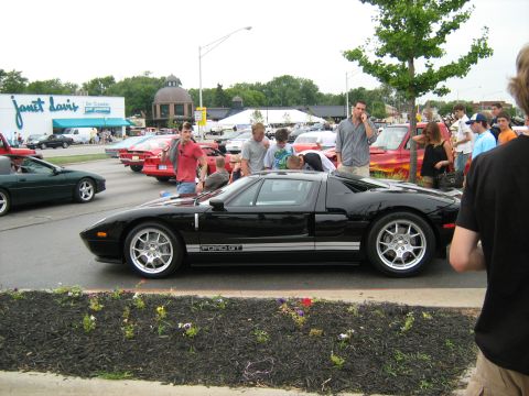 1988 Mercury Grand Marquis - A black Ford GT is parked at a car show, with spectators gathered around.